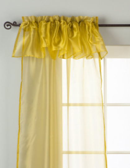 Gold sheer tissue rod pocket curtains hung at a window