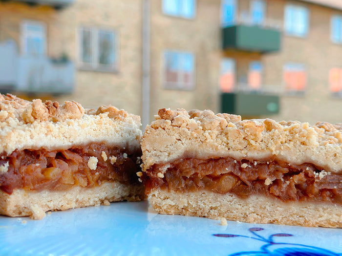 Slice of vegan gluten-free apple crumble with cinnamon-spiced apples and buttery crumble topping, baked by Gluten Tag in Copenhagen.